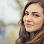 Close-up portrait of a smiling young woman outdoors in Budapest.